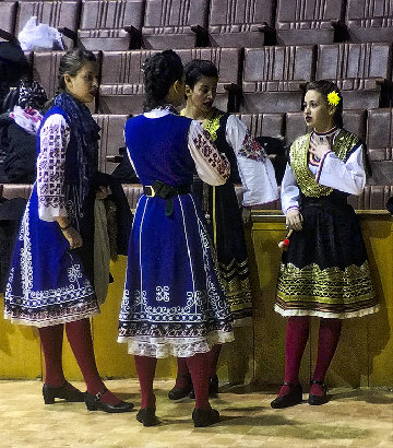 Amateur, enthusiastic folk dancers preparing, waiting or performing for a panel of judges and the audience.