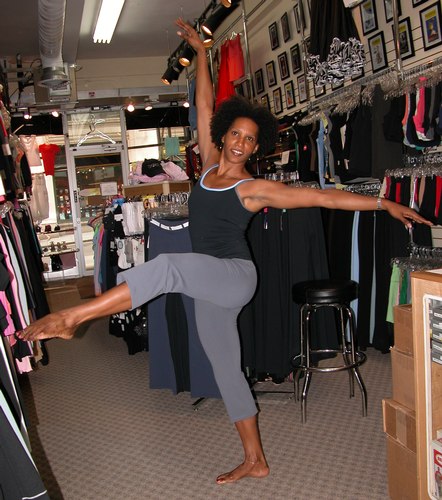Black top with cornflower blue and grey trim. Grey pants. Clothing by AMMA. Modeled by Kendra Jackson. Available at <a href='http://www.onstagedancewear.com'>OnStageDancewear.com</a>.