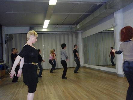 Students in Jules Helm's Advanced Cha Cha class, during warm-up. Mr. Helm (in jeans and black t-shirt) leads the class.